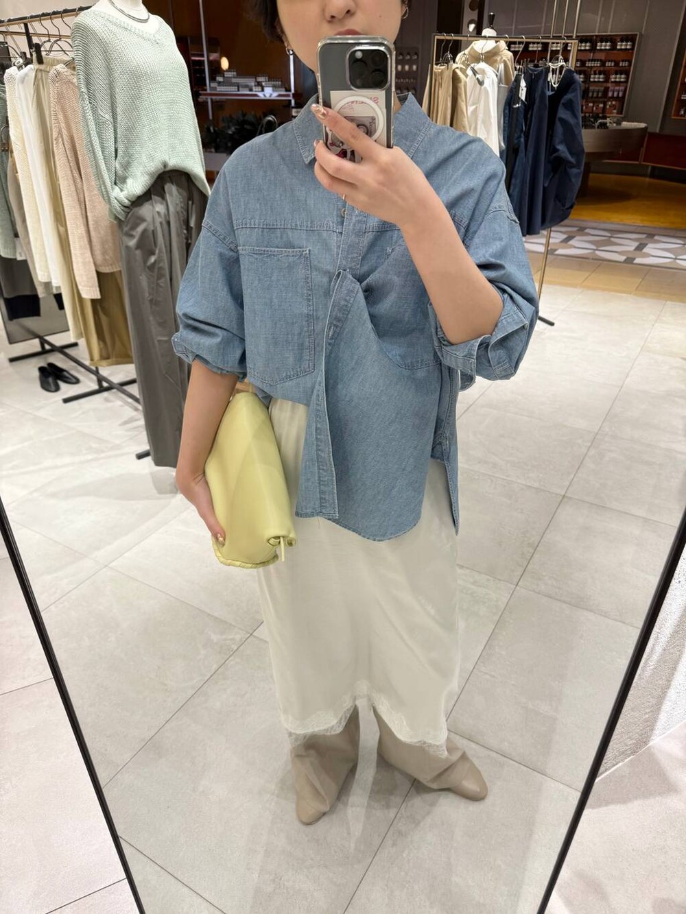 ブルー系のシャツ/ブラウス、イエロー系のハンドバッグ、ベージュ系のパンプスを着用したレディースの春コーディネートの5枚目の写真