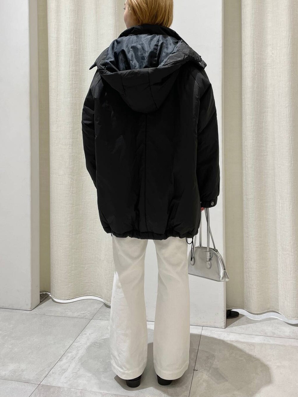 グレー系のブルゾン、ホワイト系のその他パンツ、グレー系のショルダーバッグを着用したレディースの冬コーディネートの4枚目の写真