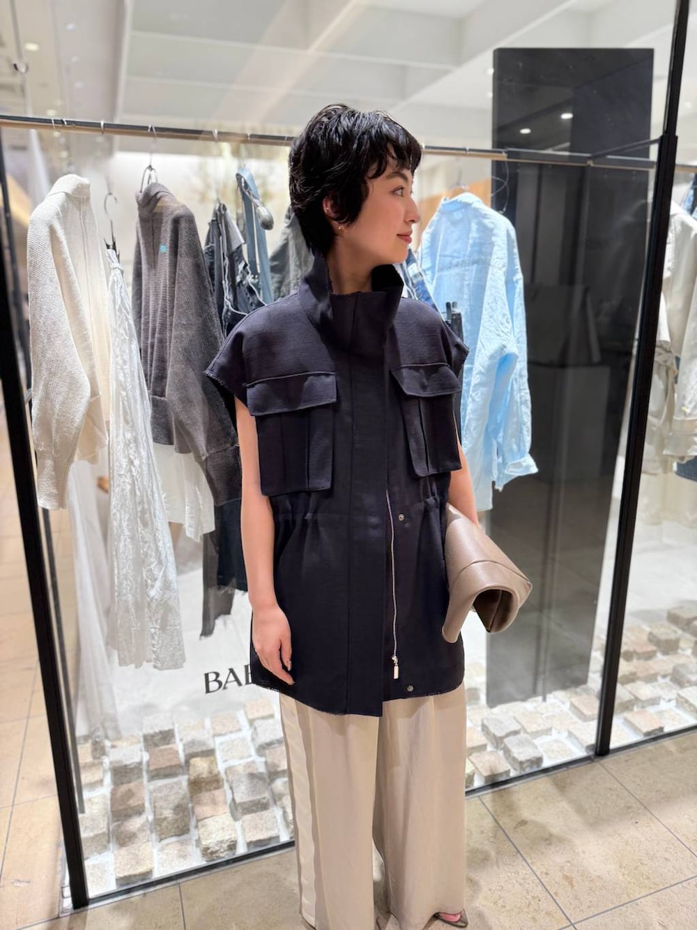 ベージュ系のその他パンツ、ベージュ系のサンダル、グレー系のベストを着用したレディースの春コーディネートの4枚目の写真