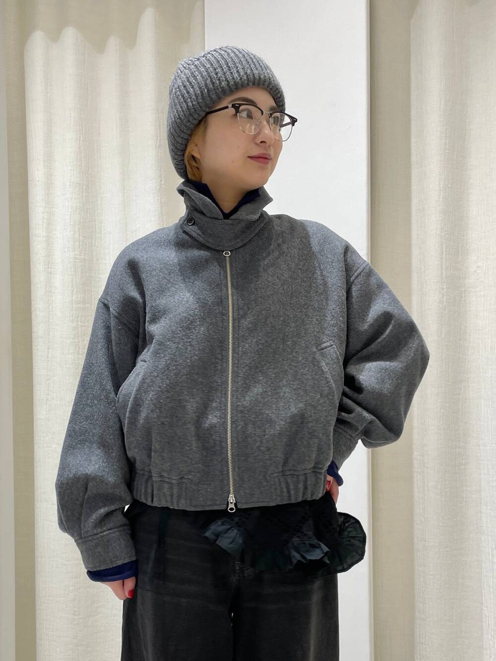 ブラック系のデニムパンツ、グレー系のブルゾン、ブルー系のニット/セーターを着用したレディースの冬コーディネートの2枚目の写真