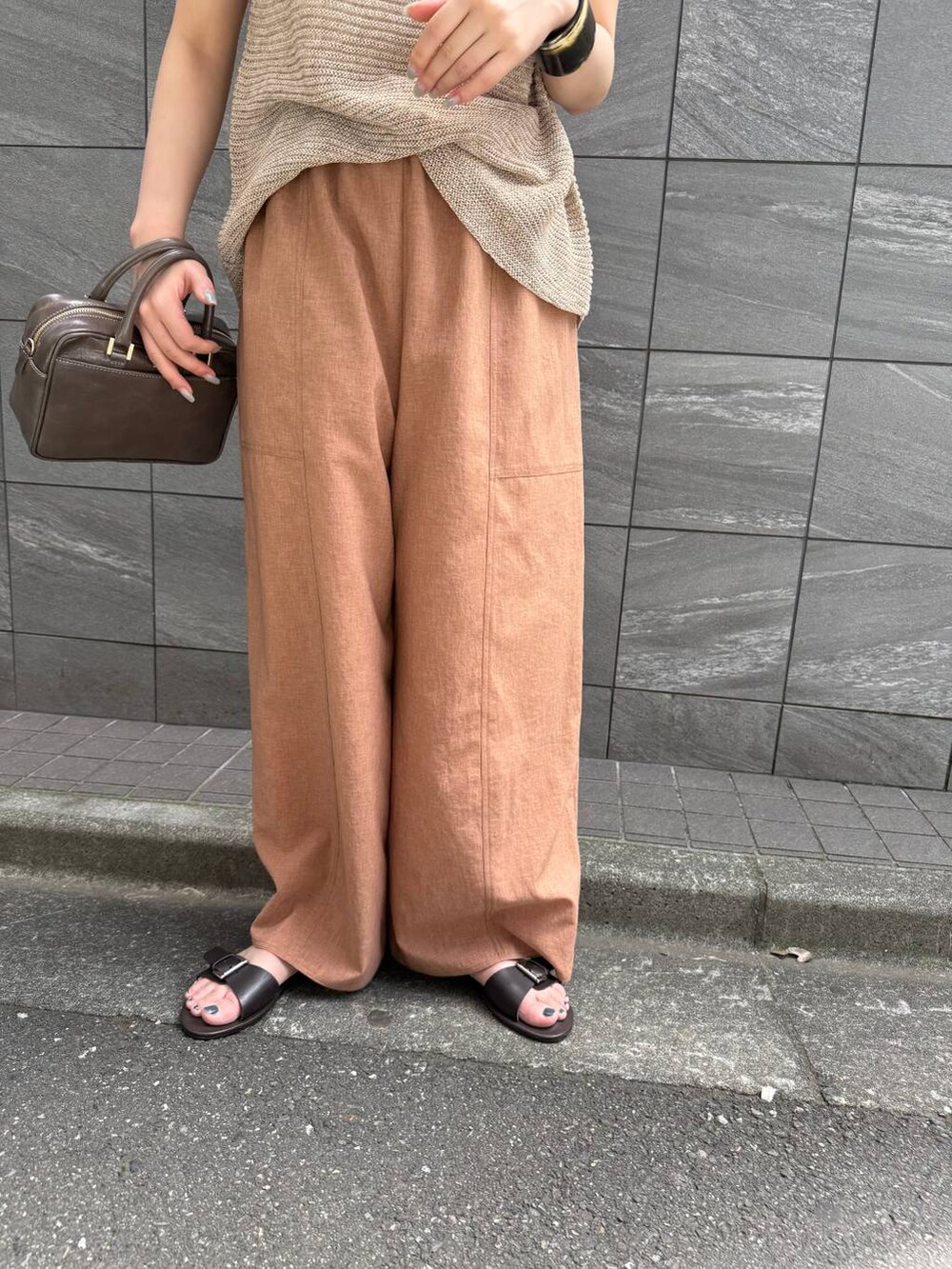 ブラウン系のその他パンツ、ベージュ系のタンクトップ、グレー系のショルダーバッグを着用したレディースの夏コーディネートの4枚目の写真