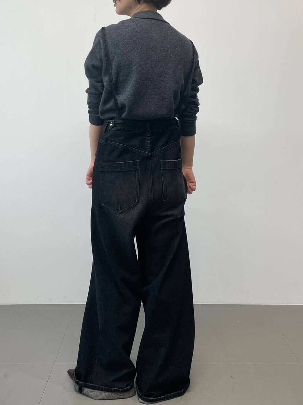 ブラック系のデニムパンツ、レッド系のパンプス、グレー系のニット/セーターを着用したレディースの秋コーディネートの3枚目の写真
