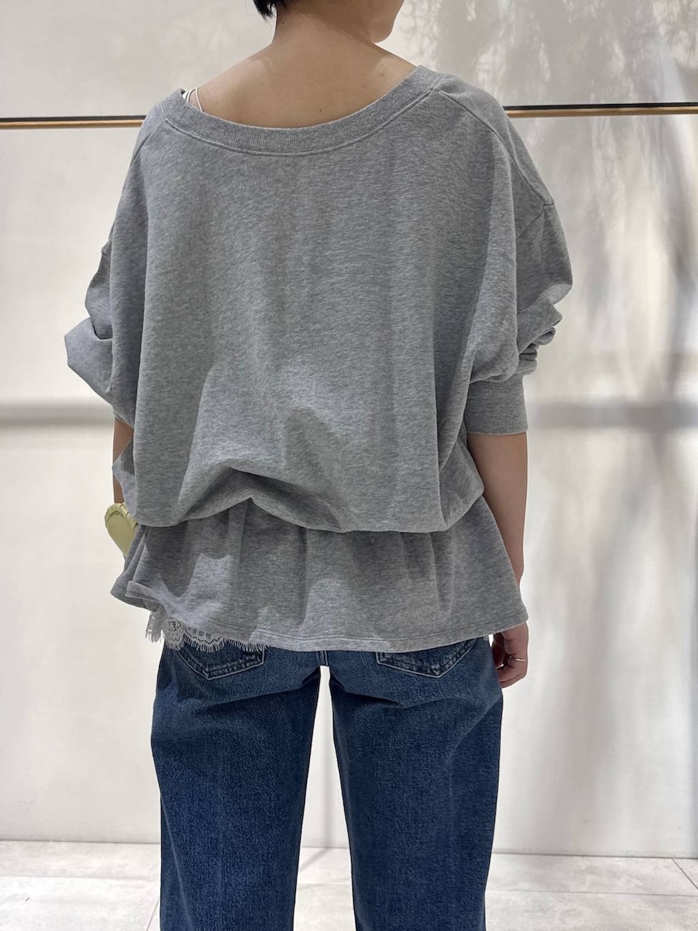 ベージュ系のサンダル、イエロー系のハンドバッグ、グレー系のスウェットを着用したレディースの春コーディネートの3枚目の写真