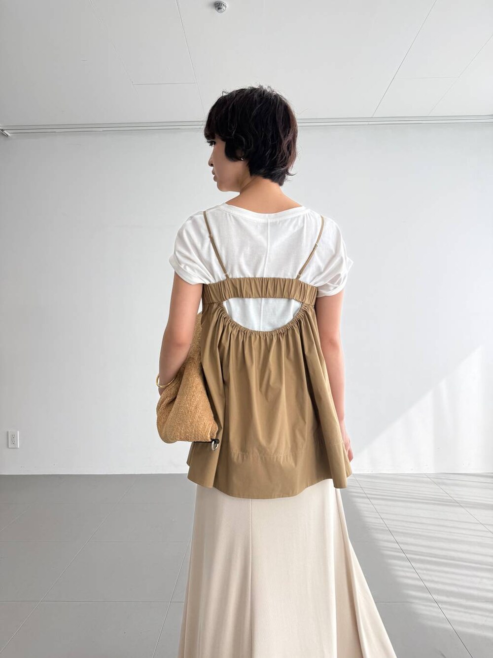 ホワイト系のTシャツ/カットソー、ベージュ系のスカート、ブラウン系のサンダルを着用したレディースの夏コーディネートの4枚目の写真