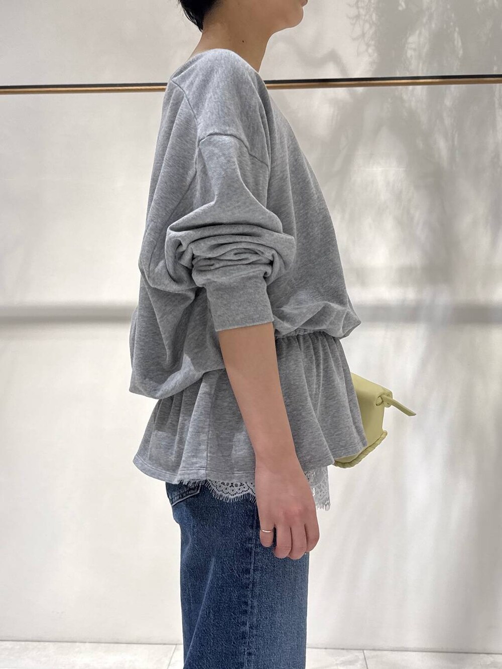 ベージュ系のサンダル、イエロー系のハンドバッグ、グレー系のスウェットを着用したレディースの春コーディネートの2枚目の写真