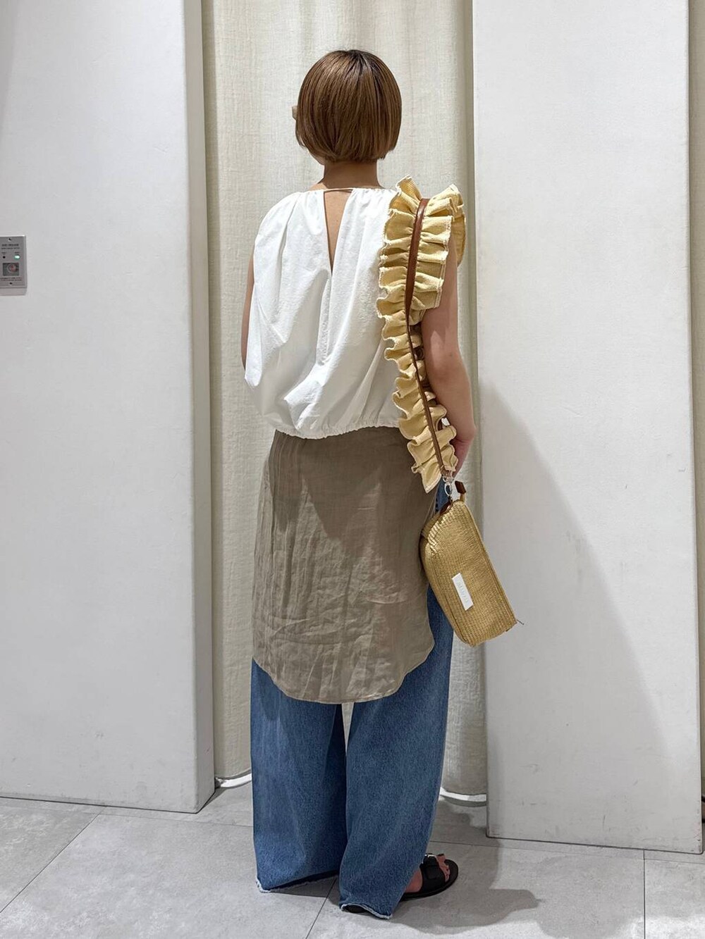 ベージュ系のショルダーバッグ、ブルー系のデニムパンツ、ベージュ系のシャツ/ブラウスを着用したレディースの春コーディネートの4枚目の写真