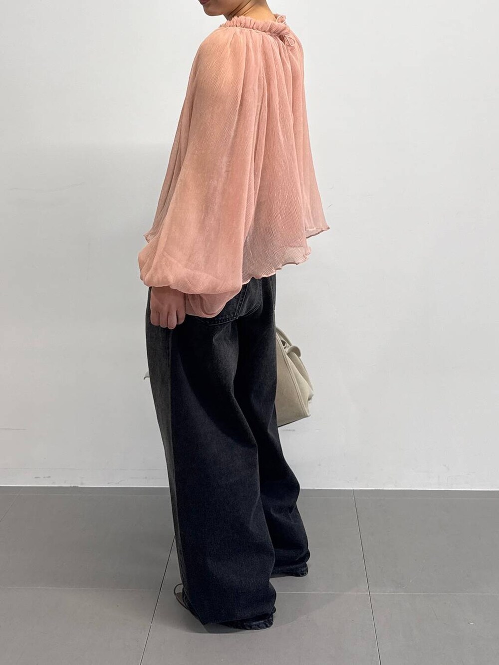 オレンジ系のキャミソール、ベージュ系のサンダル、ブラック系のデニムパンツを着用したレディースの夏コーディネートの3枚目の写真