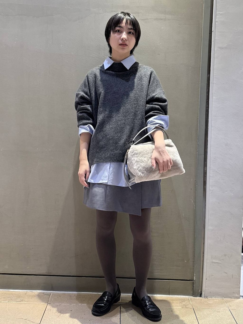 グレー系のニット/セーター、ベージュ系のハンドバッグ、グレー系のその他パンツを着用したレディースの秋コーディネートの2枚目の写真