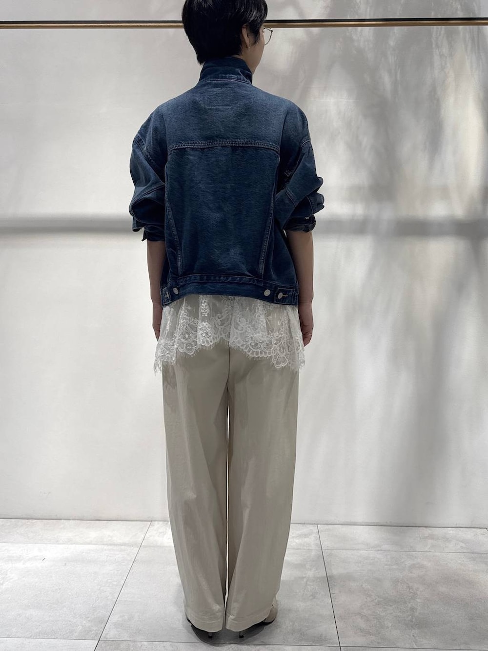 ホワイト系のキャミソール、ベージュ系のトレンチコート、ベージュ系のその他パンツを着用したレディースの冬コーディネートの2枚目の写真