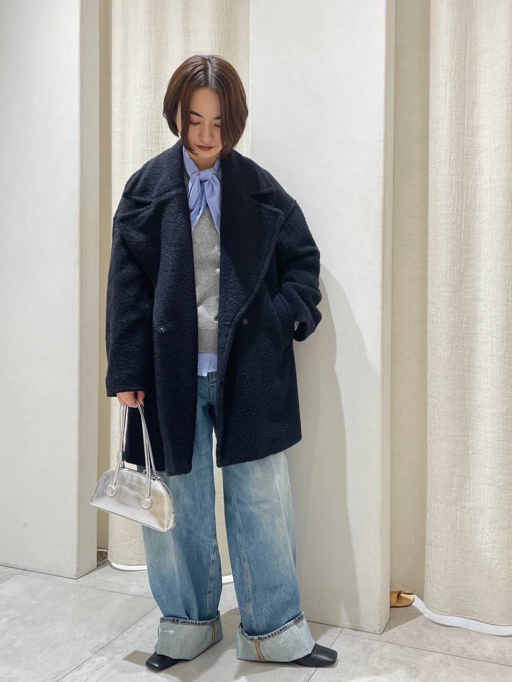 グレー系のスウェット、ブルー系のシャツ/ブラウス、ブルー系のデニムパンツを着用したレディースの秋コーディネートの2枚目の写真