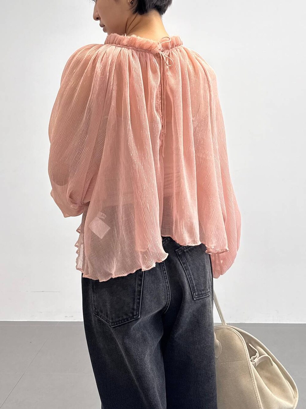 オレンジ系のキャミソール、ベージュ系のサンダル、ブラック系のデニムパンツを着用したレディースの夏コーディネートの5枚目の写真