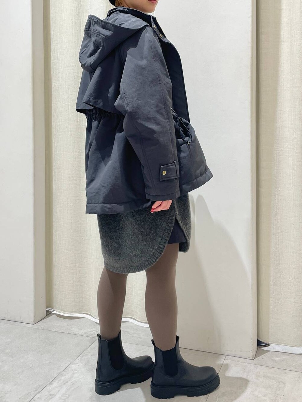 ブラック系のブーツ、グレー系のその他アウター、グレー系のワンピースを着用したレディースの冬コーディネートの3枚目の写真