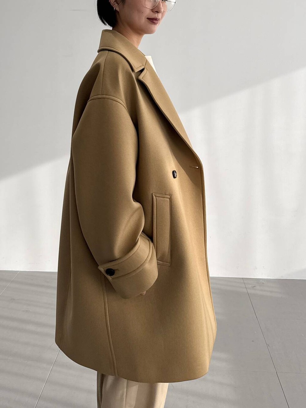 ベージュ系のその他パンツ、ベージュ系のピーコート、ブラウン系のブーツを着用したレディースの秋コーディネートの5枚目の写真