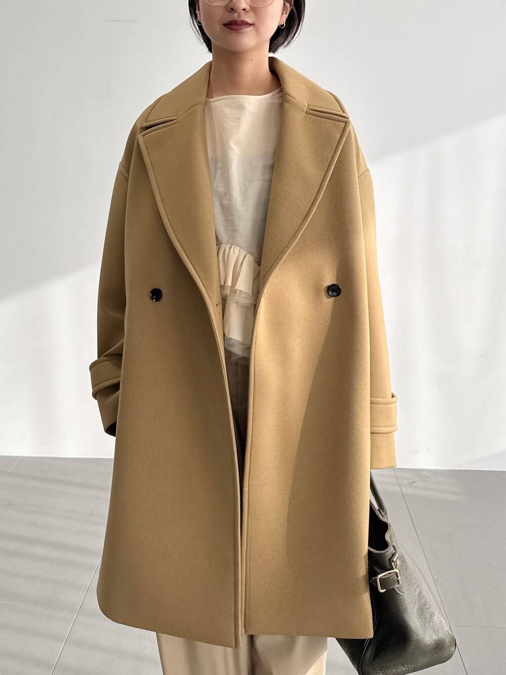 ベージュ系のその他パンツ、ベージュ系のピーコート、ブラウン系のブーツを着用したレディースの秋コーディネートの4枚目の写真