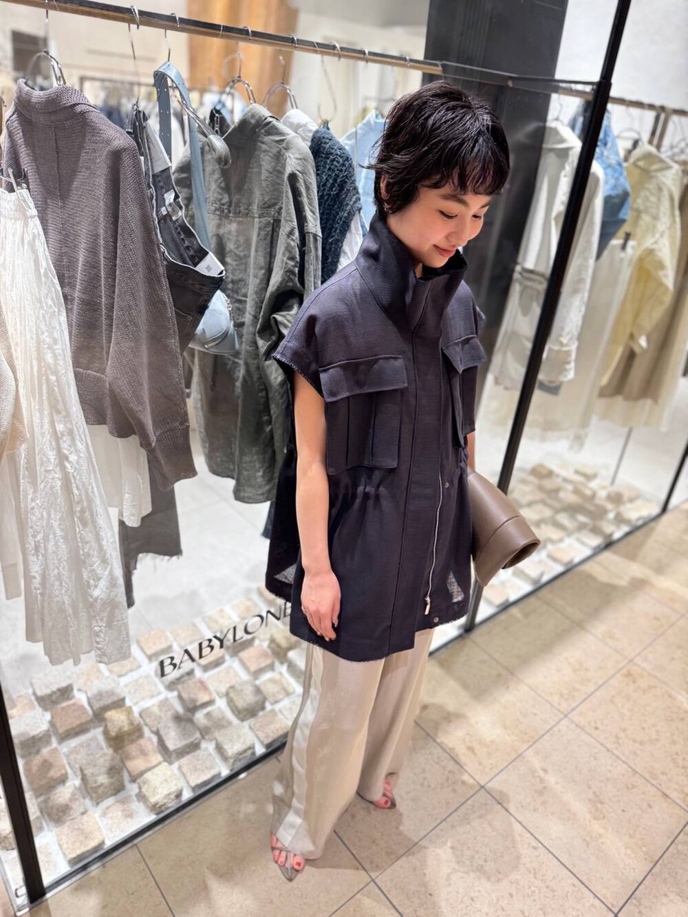 ベージュ系のその他パンツ、ベージュ系のサンダル、グレー系のベストを着用したレディースの春コーディネートの6枚目の写真