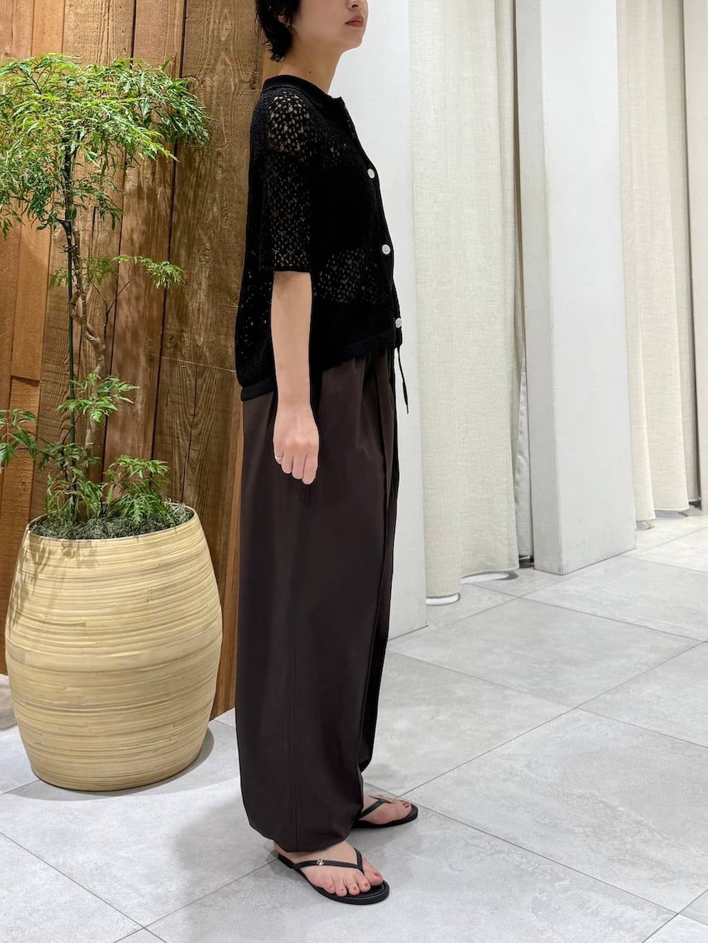 ブラウン系のその他パンツ、ブラック系のポロシャツを着用したレディースの春コーディネートの2枚目の写真