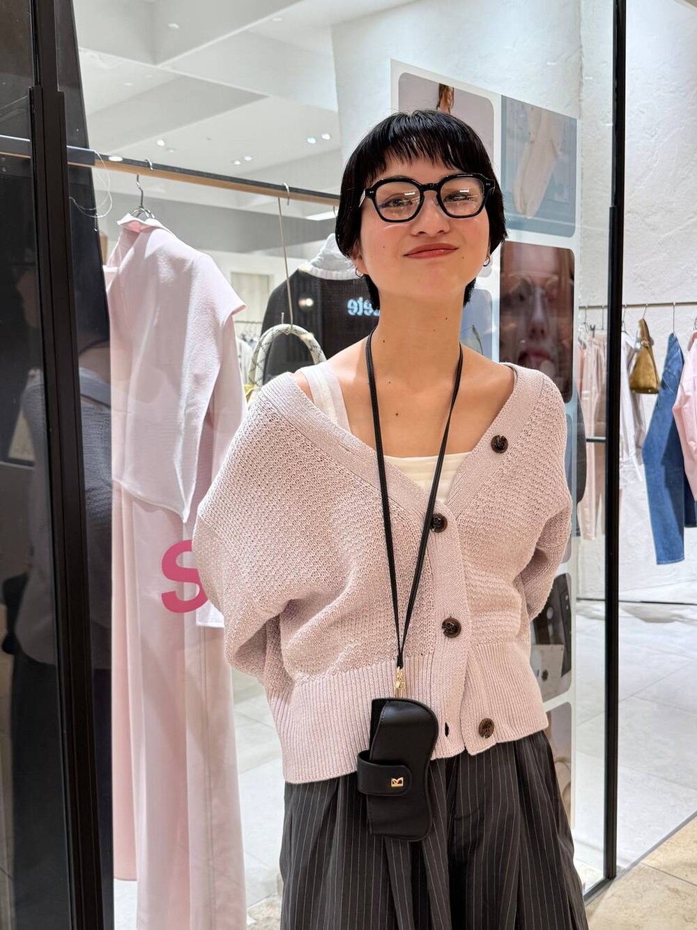 ホワイト系のタンクトップ、ピンク系のカーディガン/ボレロ、グレー系のその他パンツを着用したレディースの冬コーディネートの4枚目の写真