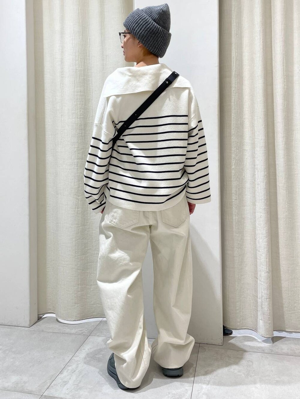 ブラック系のショルダーバッグ、グリーン系のスニーカー、ホワイト系のその他パンツを着用したレディースの冬コーディネートの3枚目の写真