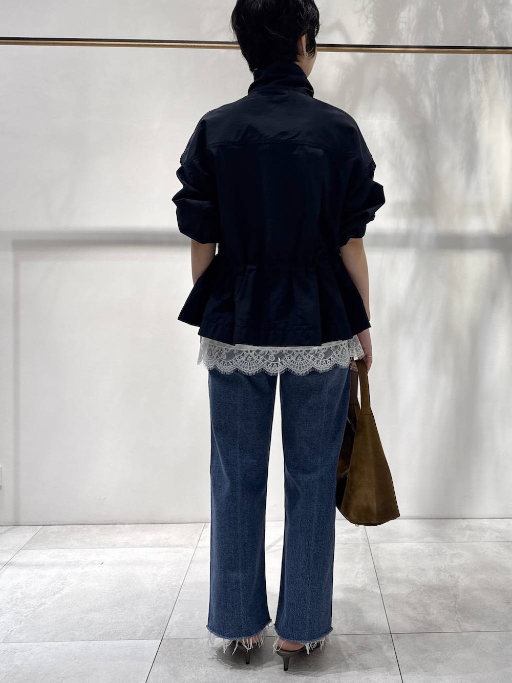 ベージュ系のサンダル、ブラウン系のハンドバッグ、ブルー系のブルゾンを着用したレディースの春コーディネートの3枚目の写真