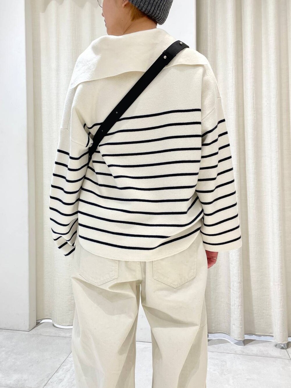 ブラック系のショルダーバッグ、グリーン系のスニーカー、ホワイト系のその他パンツを着用したレディースの冬コーディネートの5枚目の写真