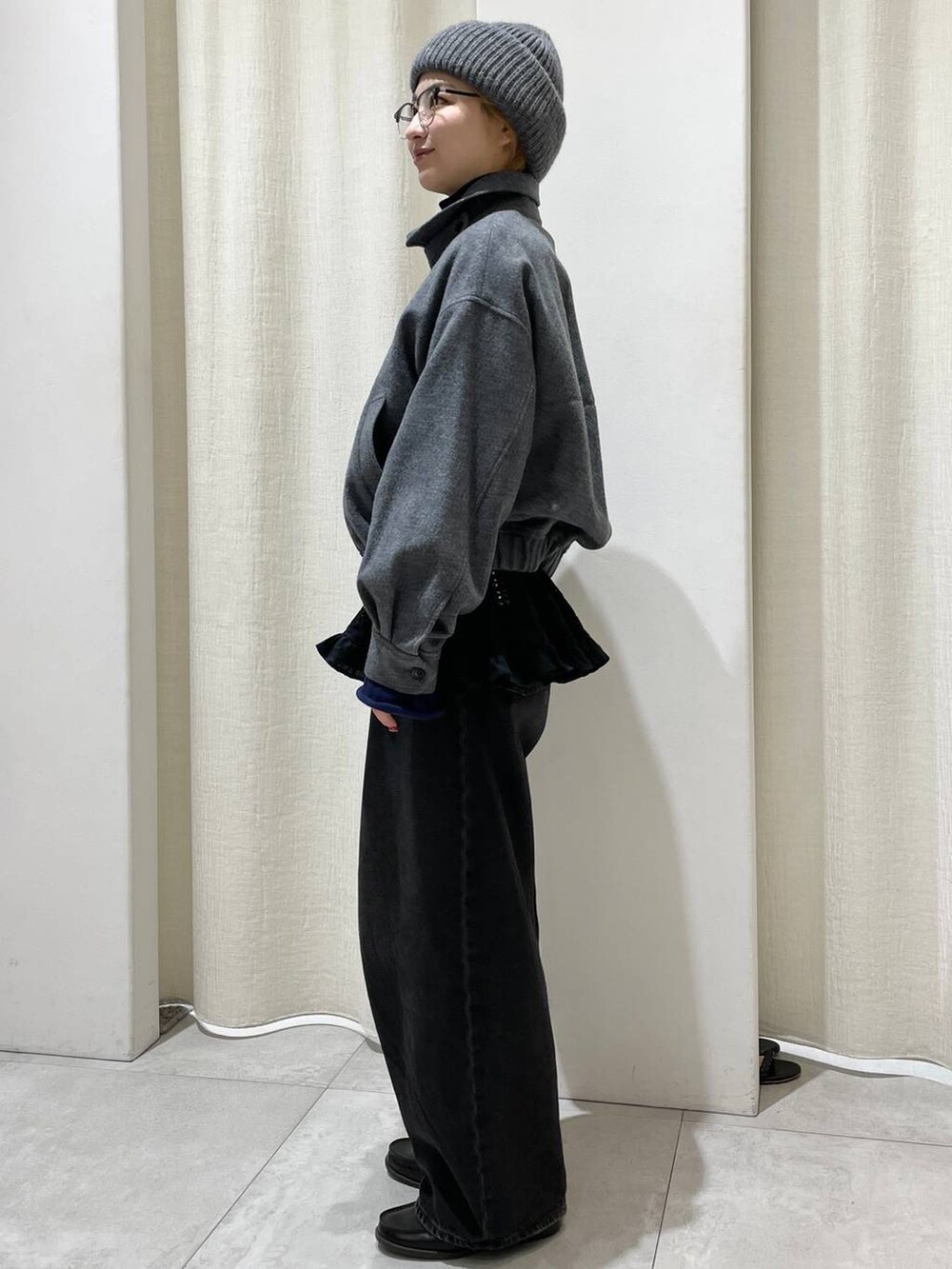 ブラック系のデニムパンツ、グレー系のブルゾン、ブルー系のニット/セーターを着用したレディースの冬コーディネートの3枚目の写真