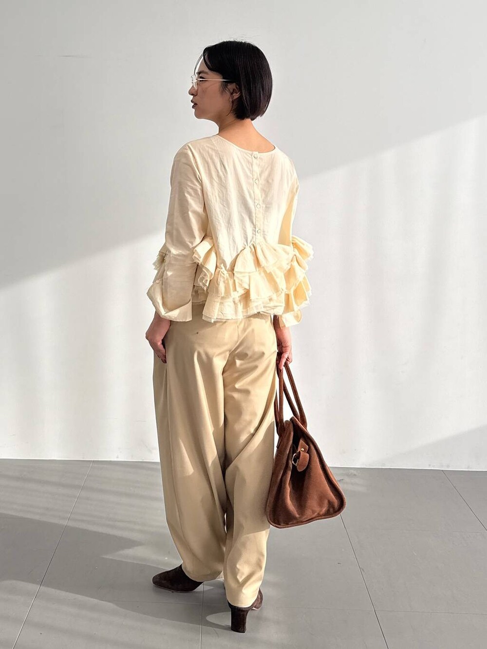 ベージュ系のその他パンツ、ブラウン系のブーツ、ベージュ系のシャツ/ブラウスを着用したレディースの秋コーディネートの3枚目の写真