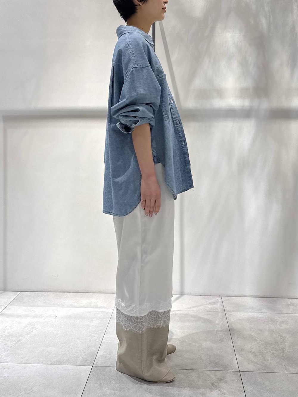 ブルー系のシャツ/ブラウス、イエロー系のハンドバッグ、ベージュ系のパンプスを着用したレディースの春コーディネートの3枚目の写真