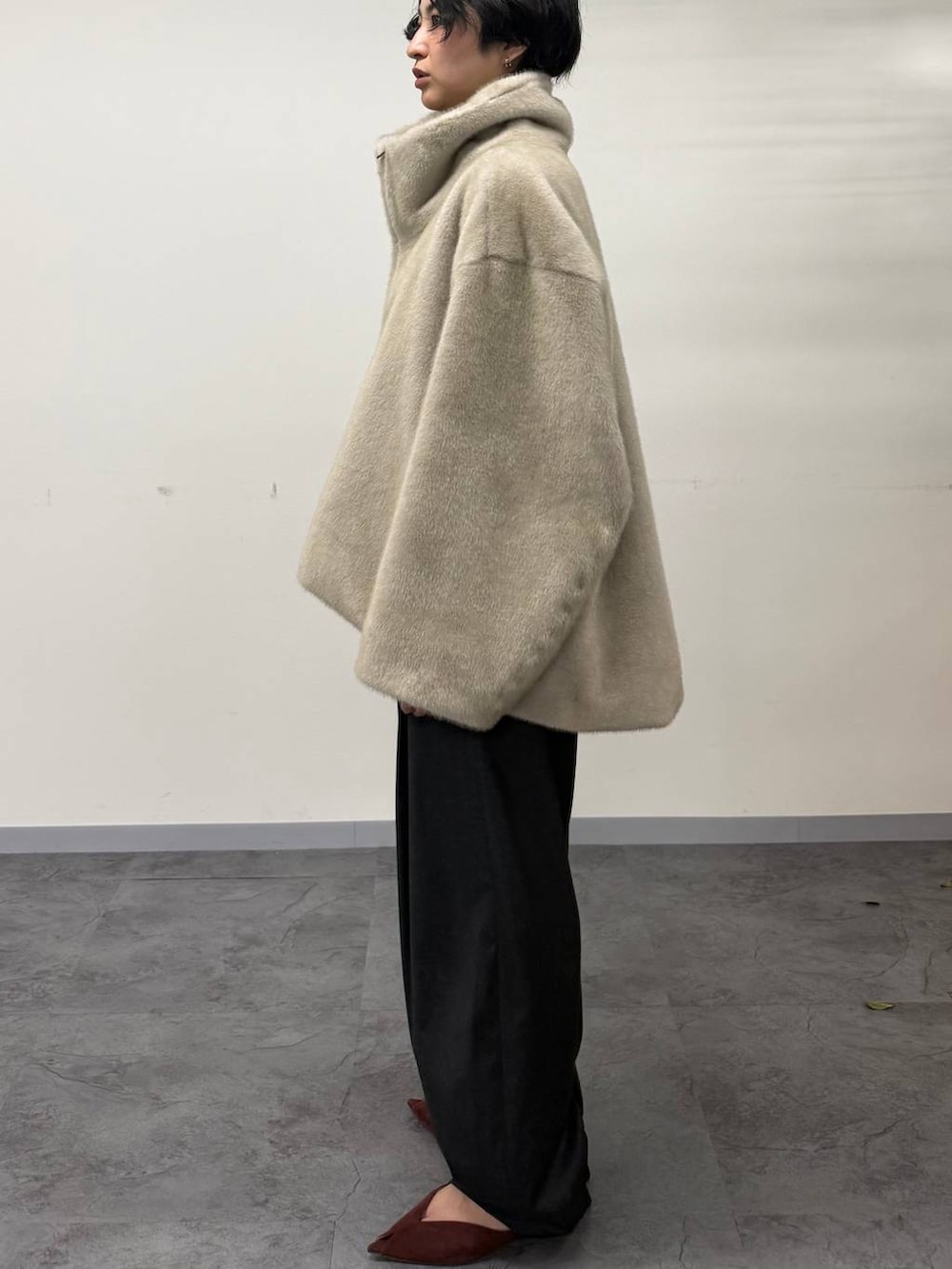 レッド系のパンプス、グレー系のその他パンツ、ベージュ系のムートンコートを着用したレディースの秋コーディネートの3枚目の写真
