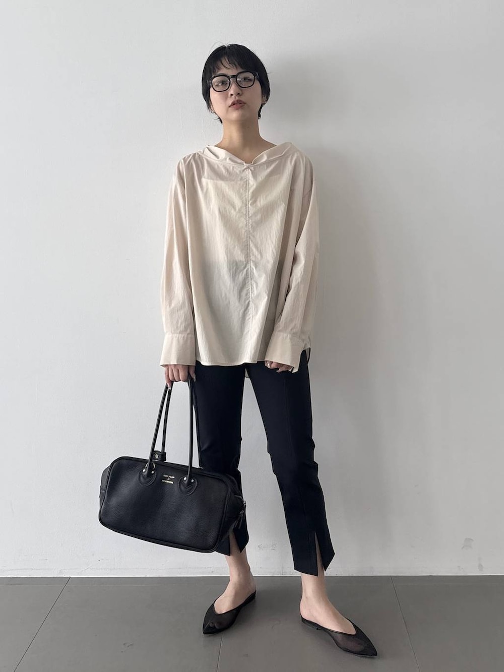 ブラック系のその他パンツ、ベージュ系のシャツ/ブラウス、ブラック系のボストンバッグを着用したレディースの春コーディネートの6枚目の写真