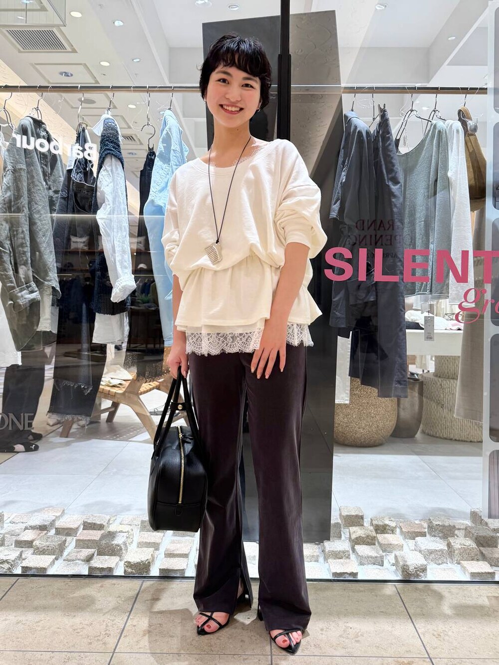 ブラック系のサンダル、ホワイト系のスウェット、ホワイト系のキャミソールを着用したレディースの春コーディネートの2枚目の写真