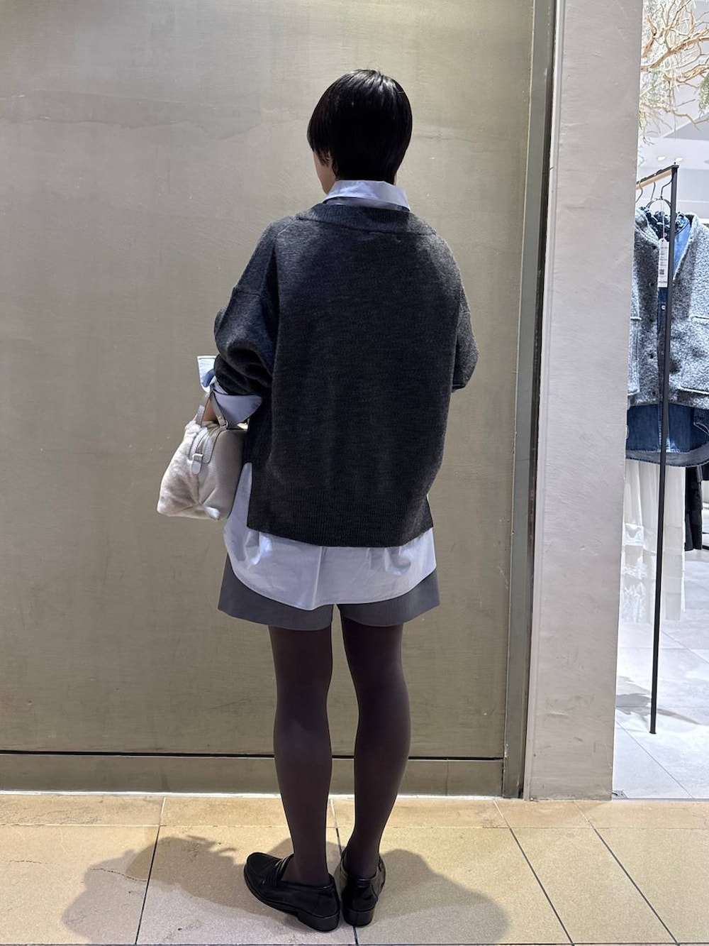 グレー系のニット/セーター、ベージュ系のハンドバッグ、グレー系のその他パンツを着用したレディースの秋コーディネートの3枚目の写真