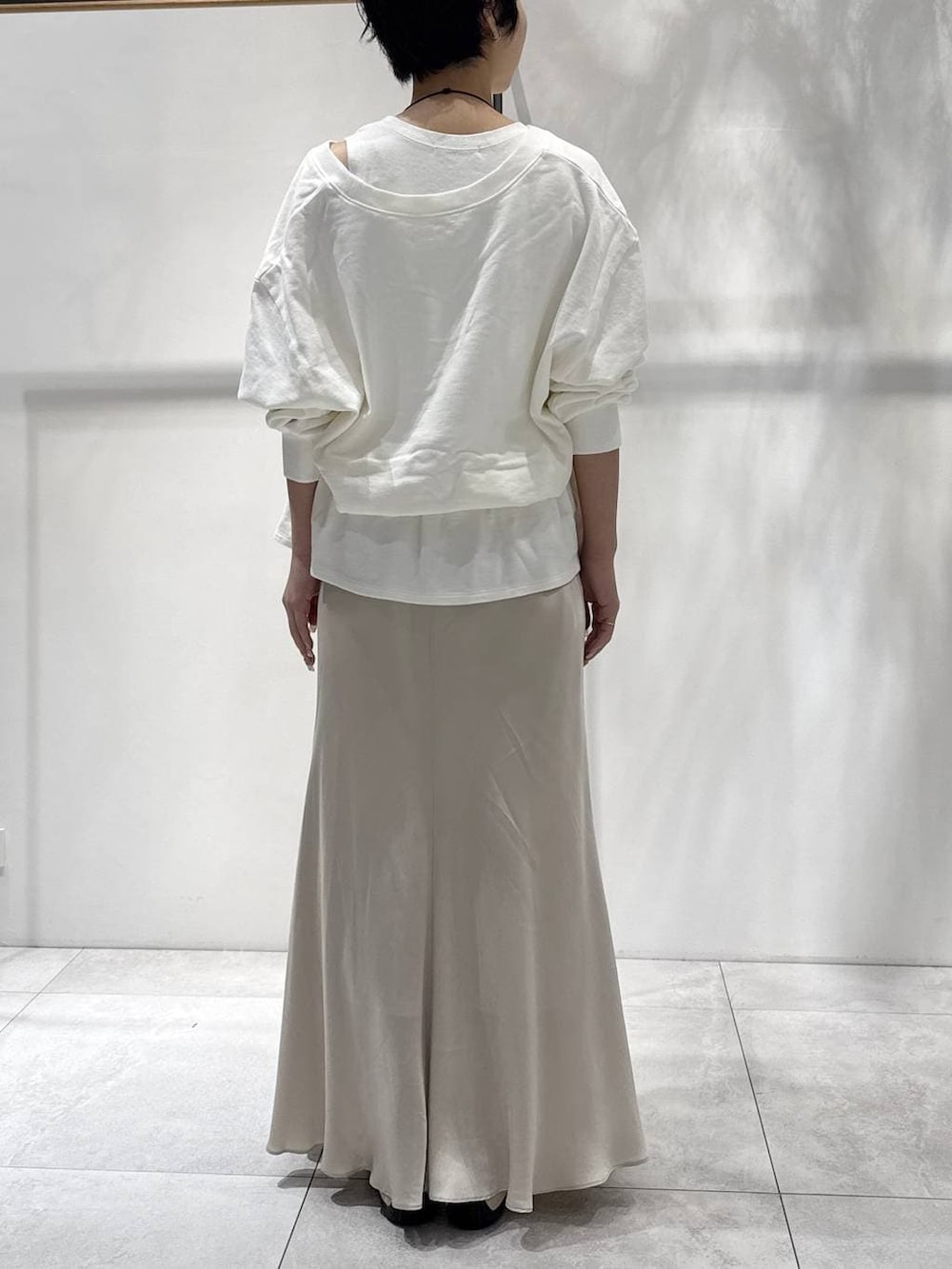 ベージュ系のスカート、ベージュ系のスニーカー、ホワイト系のスウェットを着用したレディースの春コーディネートの2枚目の写真