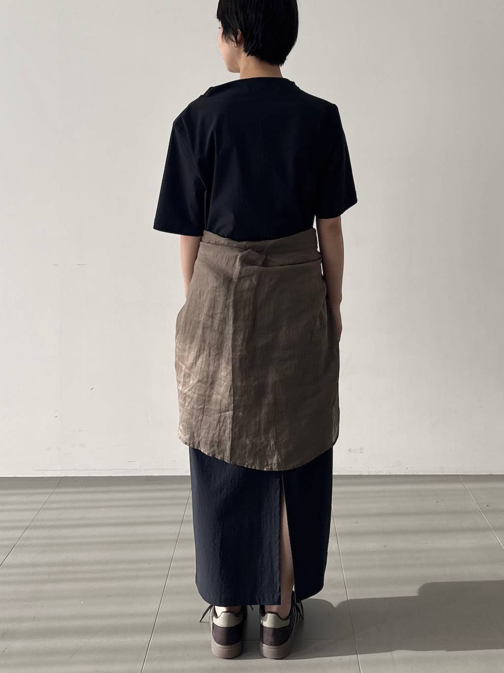 ブラウン系のスニーカー、ブラック系のワンピース、グリーン系のシャツ/ブラウスを着用したレディースの春コーディネートの3枚目の写真