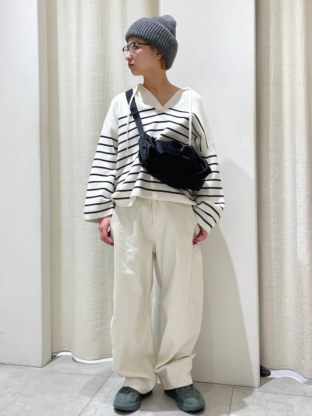 ブラック系のショルダーバッグ、グリーン系のスニーカー、ホワイト系のその他パンツを着用したレディースの冬コーディネートの2枚目の写真