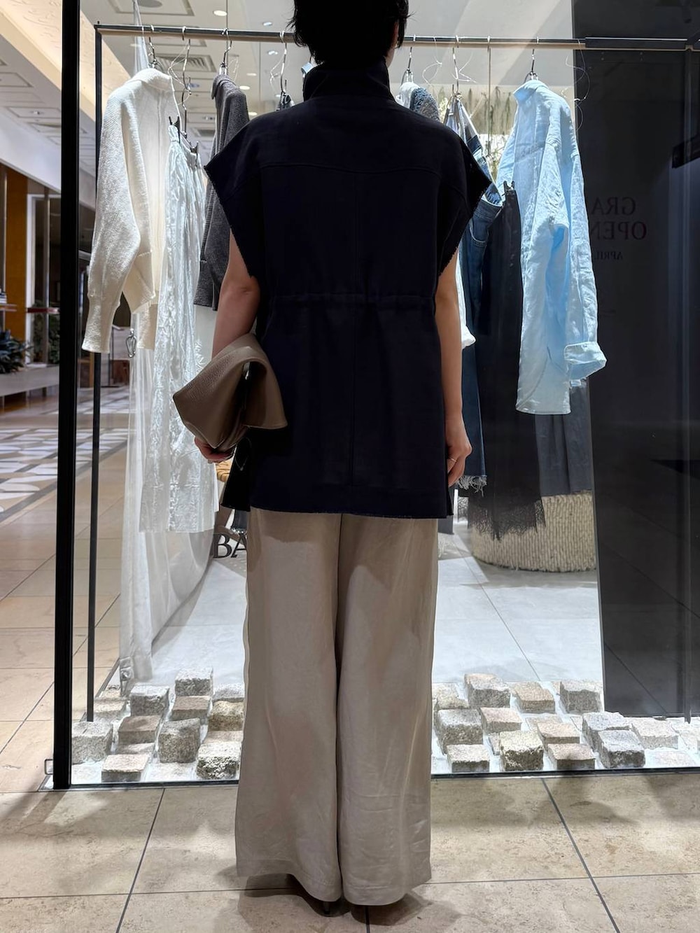 ベージュ系のその他パンツ、ベージュ系のサンダル、グレー系のベストを着用したレディースの春コーディネートの3枚目の写真