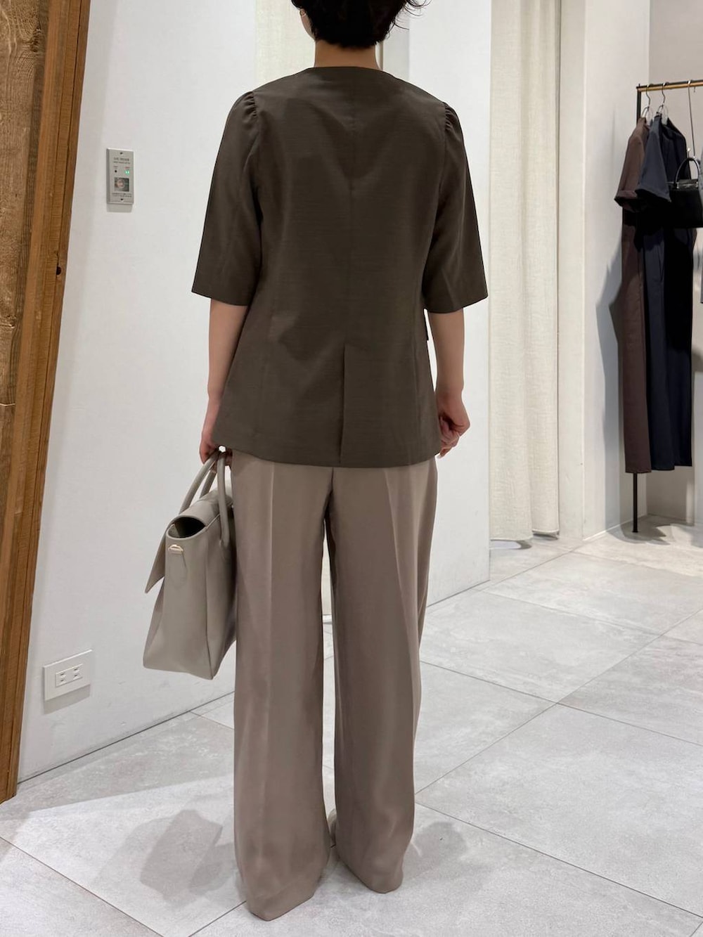 ベージュ系のパンプス、ブラウン系のノーカラージャケット、ベージュ系のスラックスを着用したレディースの春コーディネートの4枚目の写真