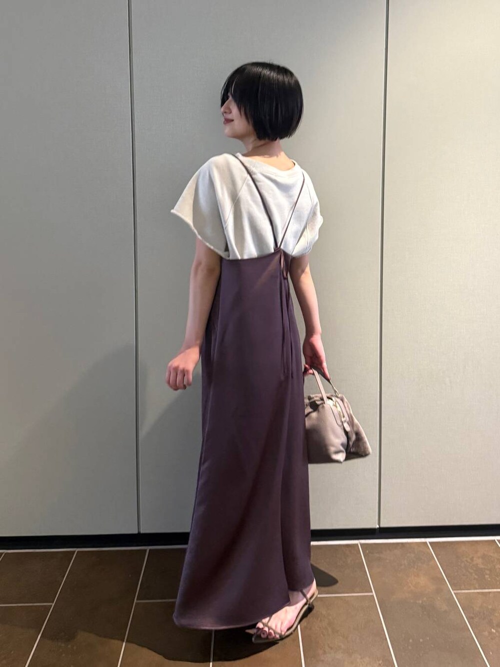 ブラウン系のワンピース、ベージュ系のTシャツ/カットソー、ベージュ系のサンダルを着用したレディースの夏コーディネートの2枚目の写真