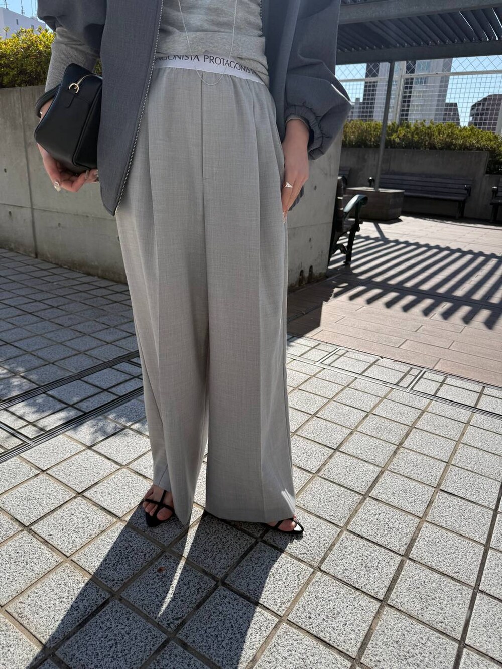 ブラック系のサンダル、グレー系のその他パンツ、グレー系のブルゾンを着用したレディースの冬コーディネートの3枚目の写真