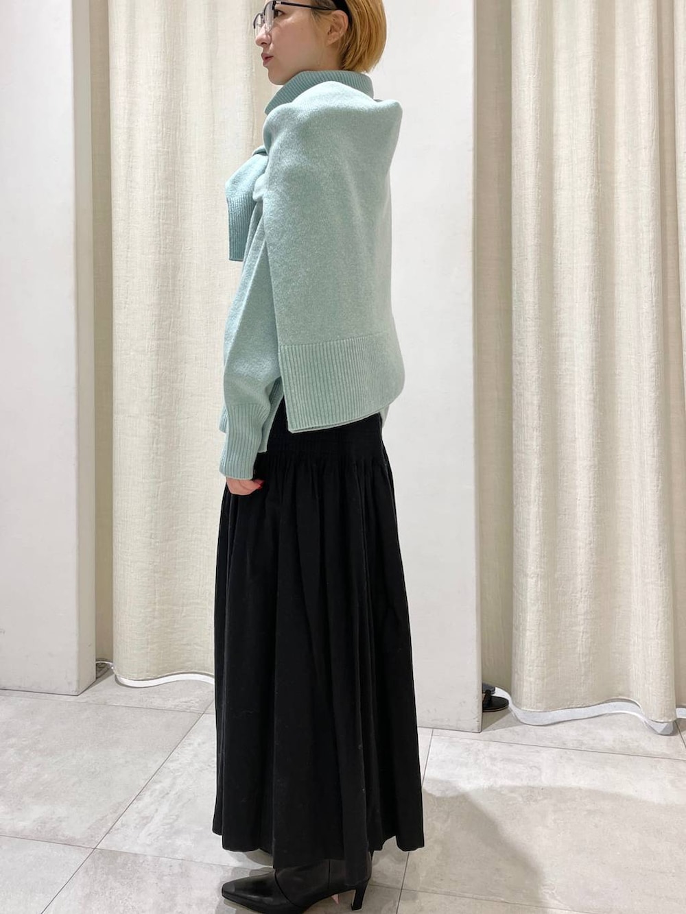 グリーン系のニット/セーター、グリーン系のニット/セーター、ブラック系のスカートを着用したレディースの冬コーディネートの4枚目の写真