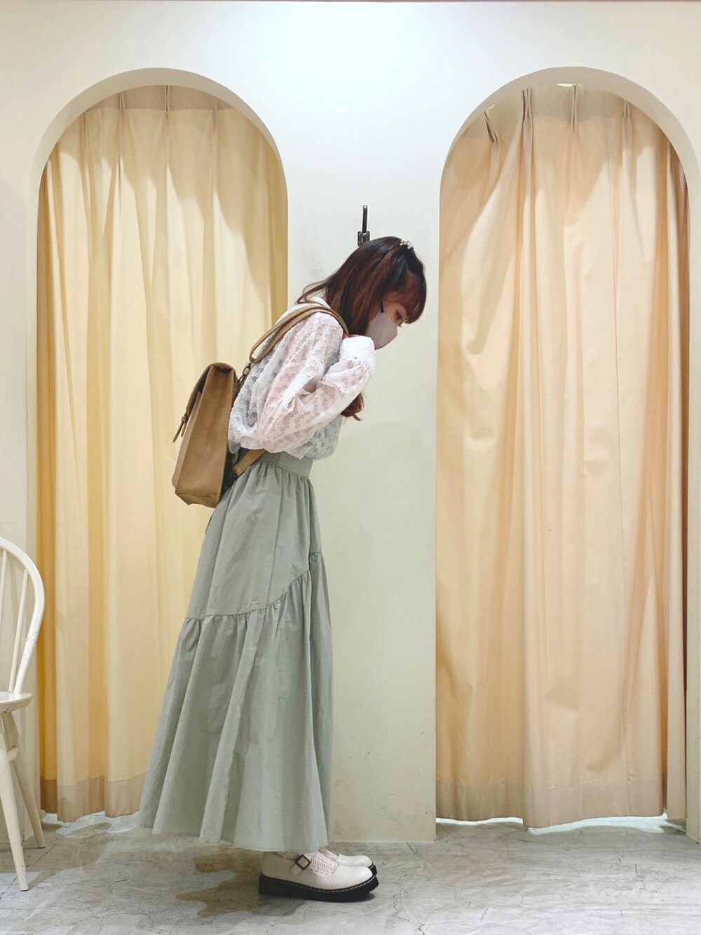 グリーン系のスカート、ベージュ系のショルダーバッグ、ホワイト系のその他シューズを着用したレディースの春コーディネートの2枚目の写真