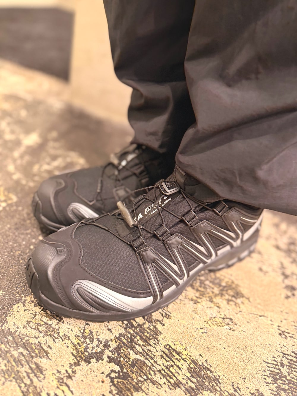 ブラック系のパーカー、ブラック系のその他パンツ、ブラック系のスニーカーを着用したメンズの秋コーディネートの2枚目の写真