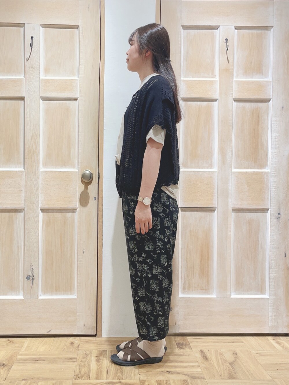 ベージュ系のTシャツ/カットソー、ブラック系のその他パンツ、ブラウン系のサンダルを着用したレディースの春コーディネートの2枚目の写真