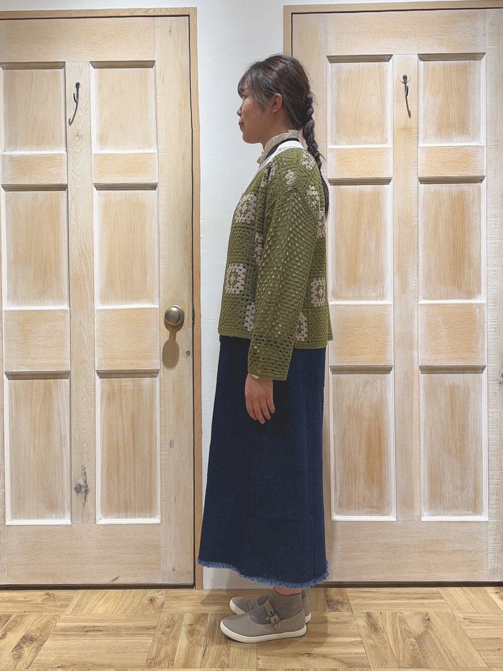 グリーン系のカーディガン/ボレロ、ブルー系のワンピース、ブラウン系のスニーカーを着用したレディースの秋コーディネートの2枚目の写真