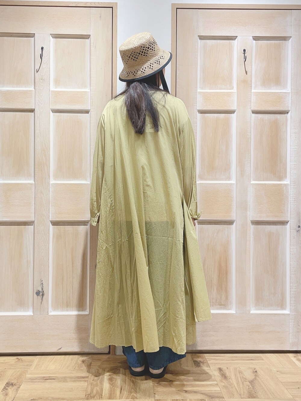 ホワイト系のTシャツ/カットソー、イエロー系のワンピース、ブルー系のデニムパンツを着用したレディースの春コーディネートの3枚目の写真