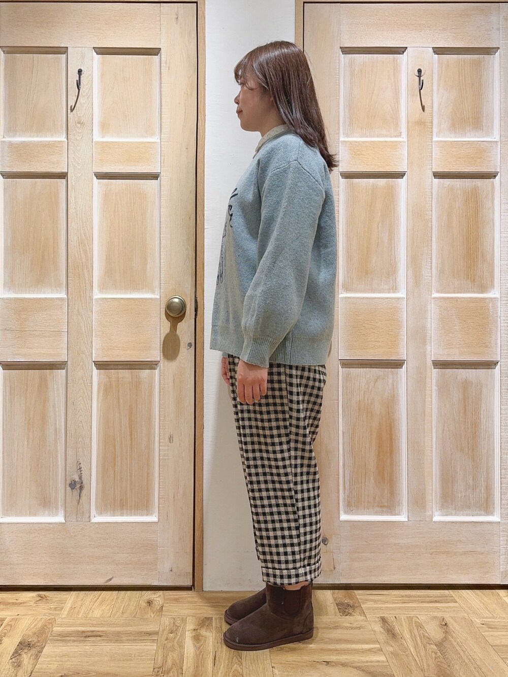 グリーン系のニット/セーター、ベージュ系のその他パンツ、ブラウン系のブーツを着用したレディースの冬コーディネートの2枚目の写真