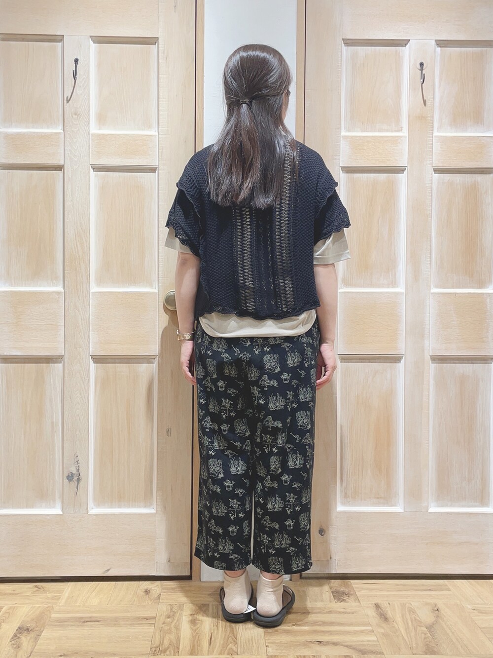 ベージュ系のTシャツ/カットソー、ブラック系のその他パンツ、ブラウン系のサンダルを着用したレディースの春コーディネートの3枚目の写真