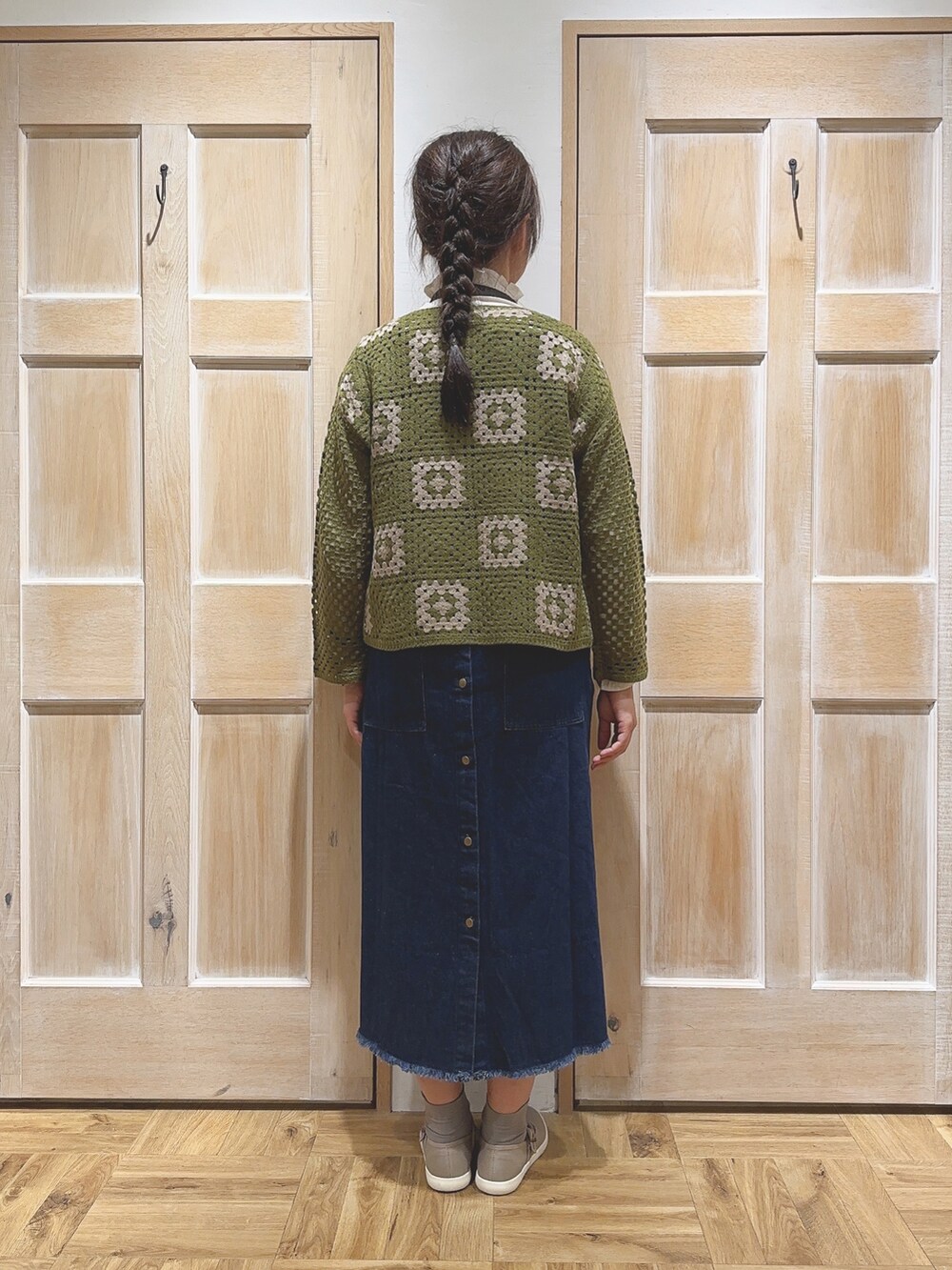 グリーン系のカーディガン/ボレロ、ブルー系のワンピース、ブラウン系のスニーカーを着用したレディースの秋コーディネートの3枚目の写真