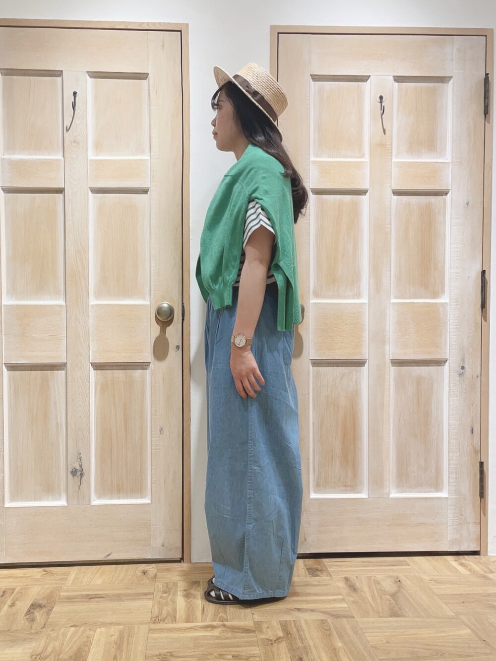 ブルー系のデニムパンツ、グリーン系のTシャツ/カットソー、グリーン系のカーディガン/ボレロを着用したレディースの春コーディネートの2枚目の写真