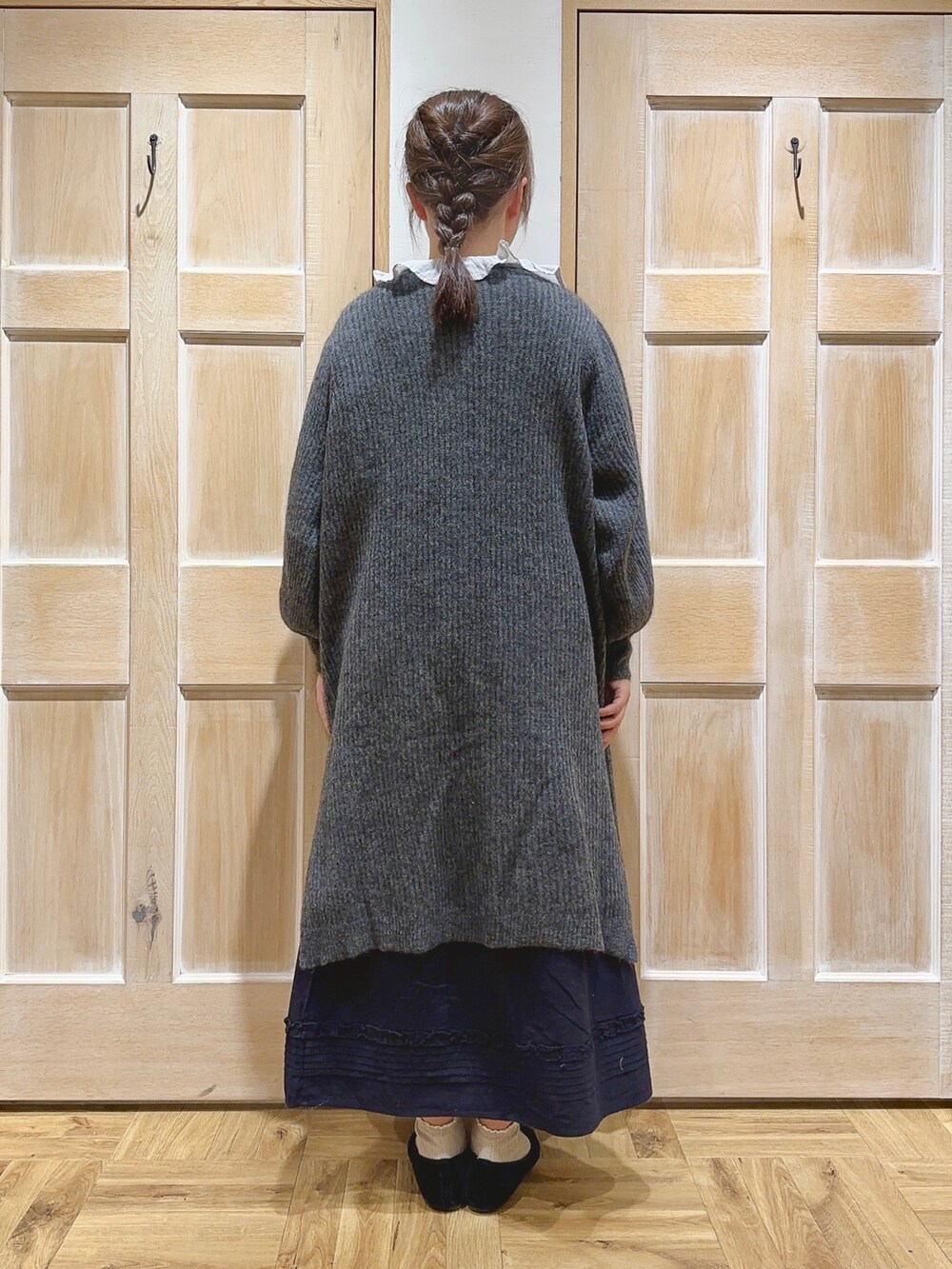 グレー系のカーディガン/ボレロ、グレー系のシャツ/ブラウス、ブラック系のスカートを着用したレディースの冬コーディネートの3枚目の写真