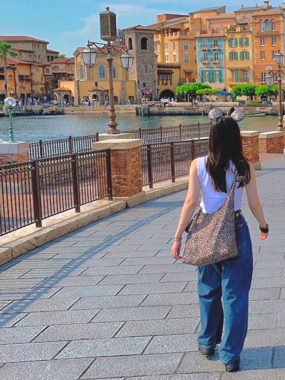 ブルー系のデニムパンツ、ホワイト系のタンクトップ、ブラック系のサンダルを着用したレディースの夏コーディネートの2枚目の写真